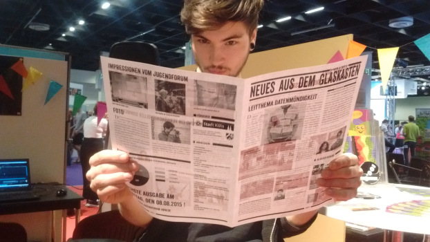 Jona liest "Neues aus dem Glaskasten", die Zeitung der Jugendredaktion des Jugendforum NRW auf der Gamescom