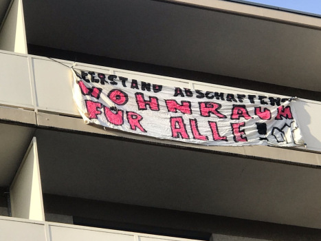 Ein Banner hängt an einem Balkon.