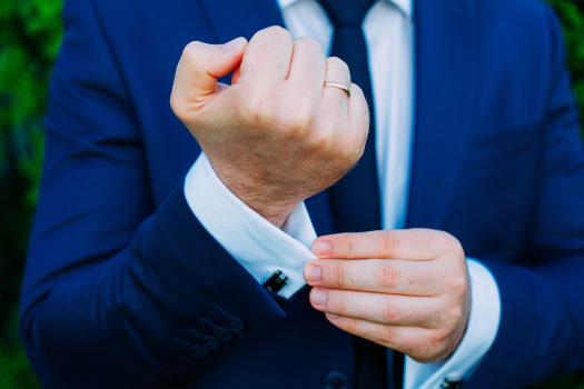 Mann in Anzug mit Ring am Finger auf einer Hochzeit.