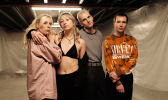 Vier Personen, offenbar die Band "Coach Party" stehen vor einem mit Folien ausgekleideten Raum.